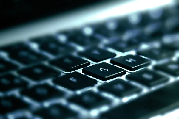 Blue tint extreme close up of computer keyboard