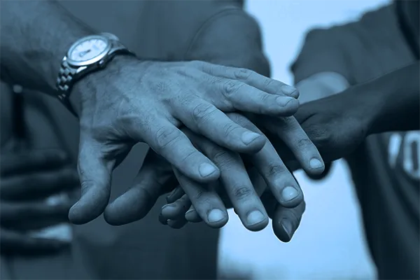 People's hands together, blue tint overlay