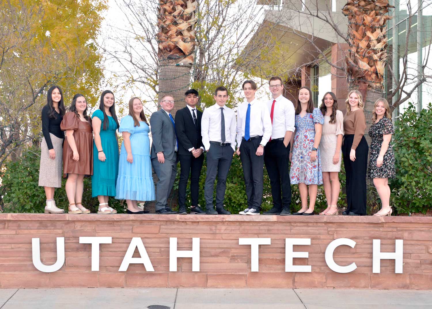 Sterling Scholar students on the fence that says UTAH TECH.